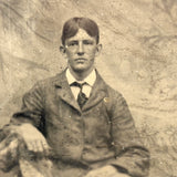 Melancholic Looking Young Man Against Whispy, Moody Painted Backdrop