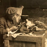 Dramatic Photo of Man at Work on Wings in Barn, with Hanging Geese and Flock of Sheep