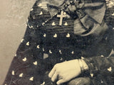 Mystical Looking Young Woman in Black Dress with Cross, Curls, and Heart-like Butterflies