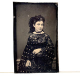 Mystical Looking Young Woman in Black Dress with Cross, Curls, and Heart-like Butterflies