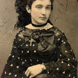 Mystical Looking Young Woman in Black Dress with Cross, Curls, and Heart-like Butterflies