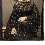 Mystical Looking Young Woman in Black Dress with Cross, Curls, and Heart-like Butterflies