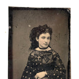 Mystical Looking Young Woman in Black Dress with Cross, Curls, and Heart-like Butterflies