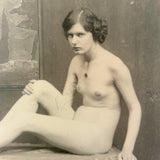 Nude Staring Back,  Loaded Antique Photograph of Model on Table with Wrinkled Fabric and Painted Backdrop