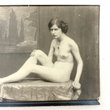 Nude Staring Back,  Loaded Antique Photograph of Model on Table with Wrinkled Fabric and Painted Backdrop
