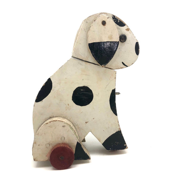 Old Black and Spotted Wooden Dog on Wheel