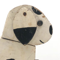 Old Black and Spotted Wooden Dog on Wheel