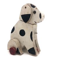 Old Black and Spotted Wooden Dog on Wheel