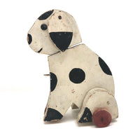 Old Black and Spotted Wooden Dog on Wheel