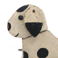 Old Black and Spotted Wooden Dog on Wheel