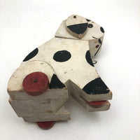 Old Black and Spotted Wooden Dog on Wheel