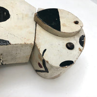 Old Black and Spotted Wooden Dog on Wheel