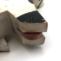 Old Black and Spotted Wooden Dog on Wheel
