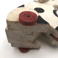 Old Black and Spotted Wooden Dog on Wheel