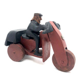 Hard-carved Man in Black with Mullet on (Three-wheeled) Motorcycle