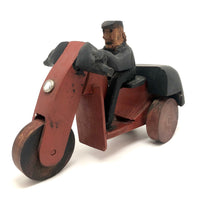 Hard-carved Man in Black with Mullet on (Three-wheeled) Motorcycle