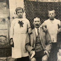 Striking Antique RPPC Family Portrait in Front of Woven Textile
